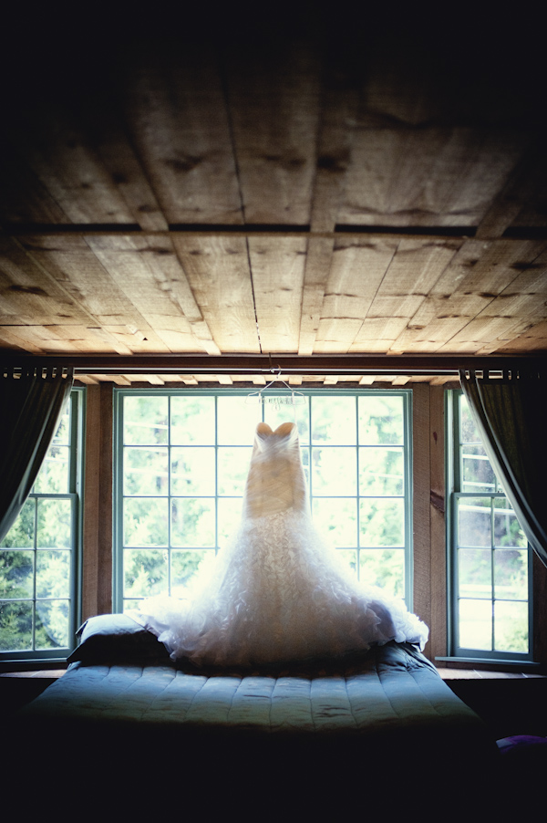 ivory wedding dress hangs in a window - wedding photo by top Atlanta based wedding photographers Scobey Photography